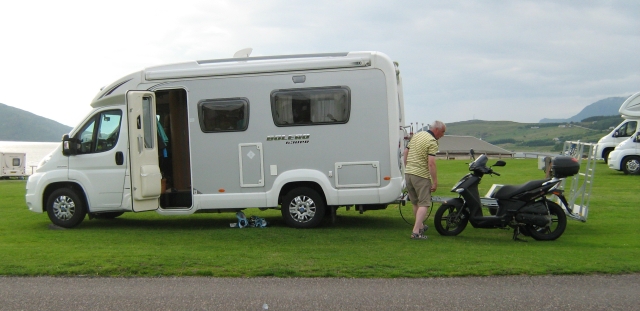 a medium sized campervan or motorhome with a scooter and trailer at ullapool